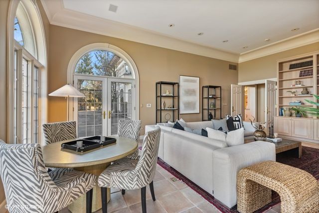 a living room with furniture a clock and a large window