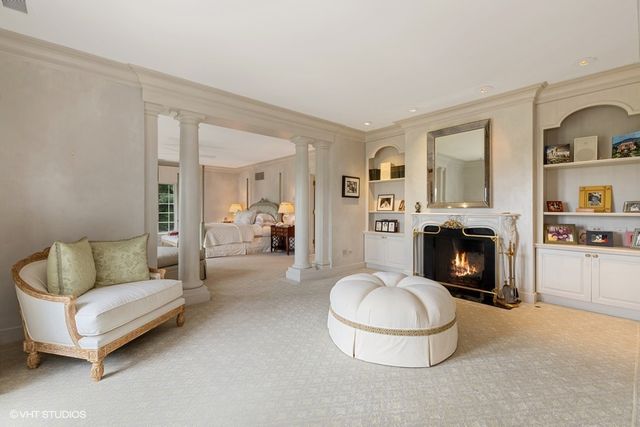 a living room with furniture a fireplace and a large mirror