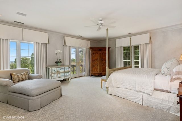 a spacious bedroom with a bed couch and window