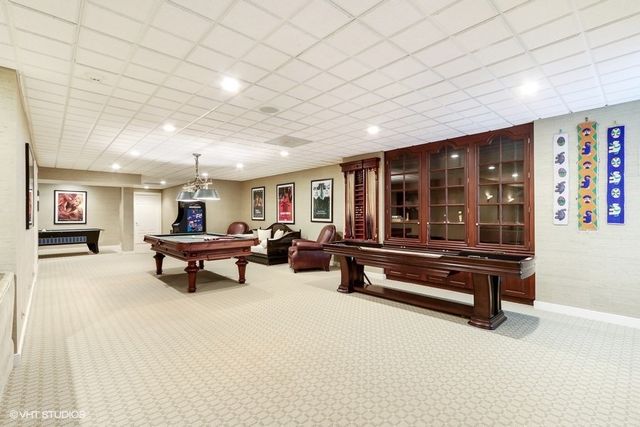 a living room with furniture a pool table and a large window