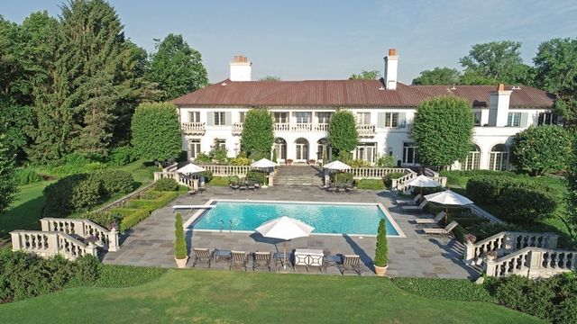 a view of a house with pool and chairs