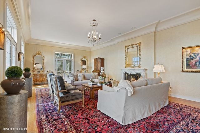 a living room with furniture a chandelier and a rug