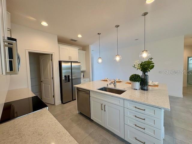 7408 Wing Span Way Harmony, FL 34773 - Photo 5 of 30 a kitchen with stainless steel appliances kitchen island granite countertop a refrigerator and a sink