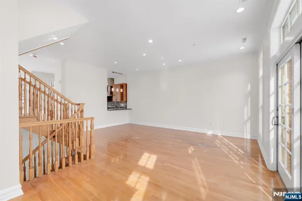 a view of a hallway with wooden floor and windows