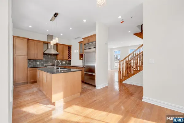 a kitchen with stainless steel appliances kitchen island granite countertop a refrigerator and a stove top oven