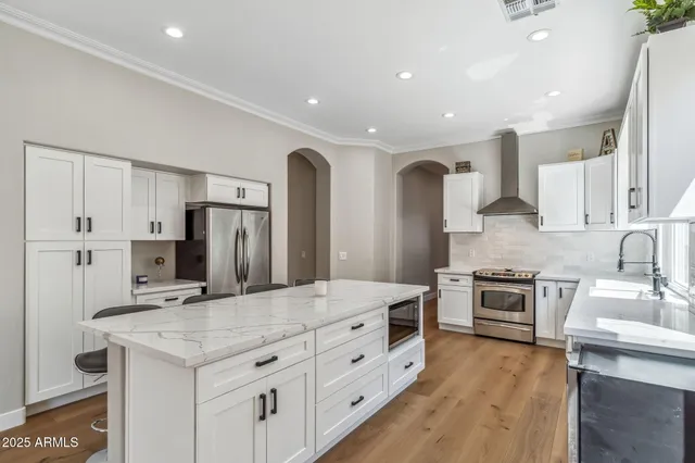 a kitchen with stainless steel appliances granite countertop a sink stove and refrigerator