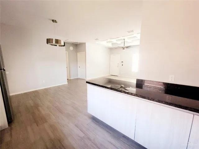 a kitchen with granite countertop a sink and a wooden floor