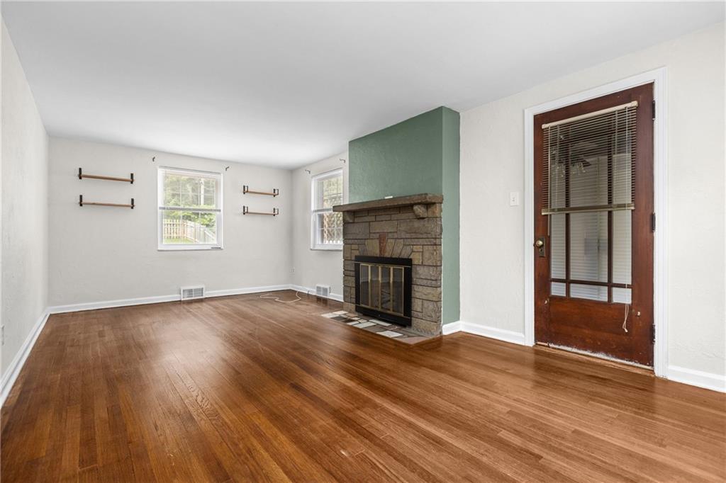630 Kelso Road Pittsburgh, PA 15243 - Photo 5 of 33 an empty room with wooden floor fireplace and windows