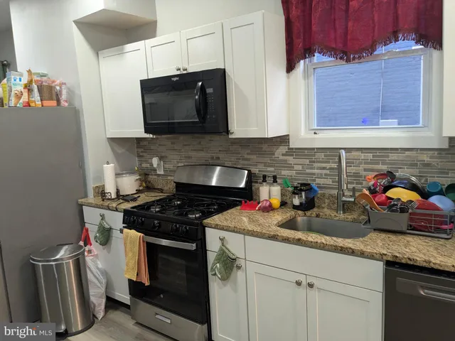 a kitchen with stainless steel appliances granite countertop a sink stove and microwave