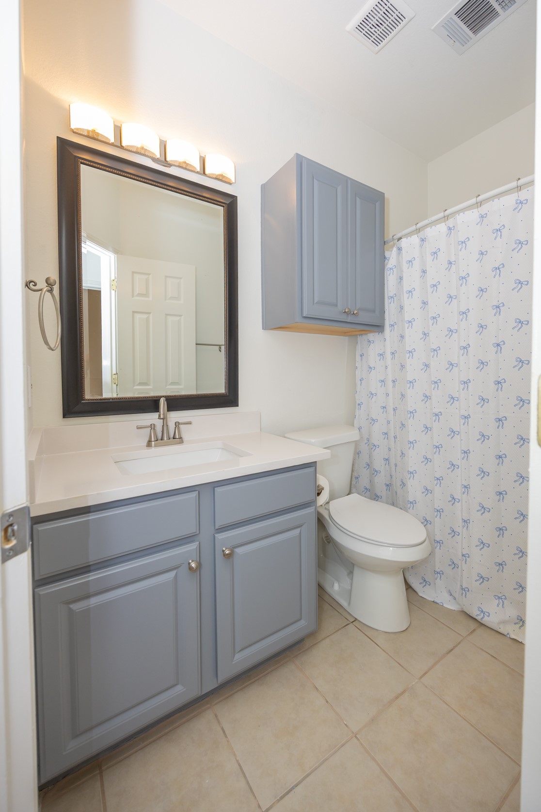 11500 Dimmit Street Manor, TX 78653 - Photo 11 of 14 Bathroom featuring a single vanity with light blue cabinetry, a white countertop, and a built-in sink