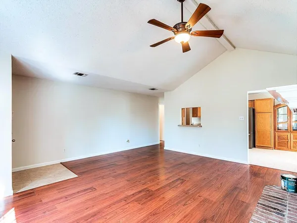 a view of room with wooden floor and ceiling fan