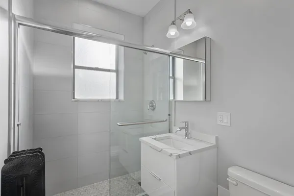 a bathroom with a granite countertop sink toilet and mirror
