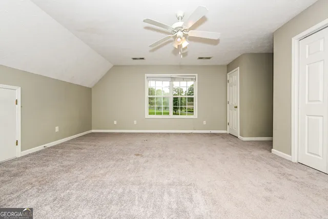 an empty room with chandelier fan