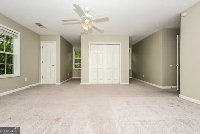 an empty room with windows and closet
