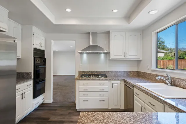a kitchen with stainless steel appliances granite countertop a sink stove and refrigerator