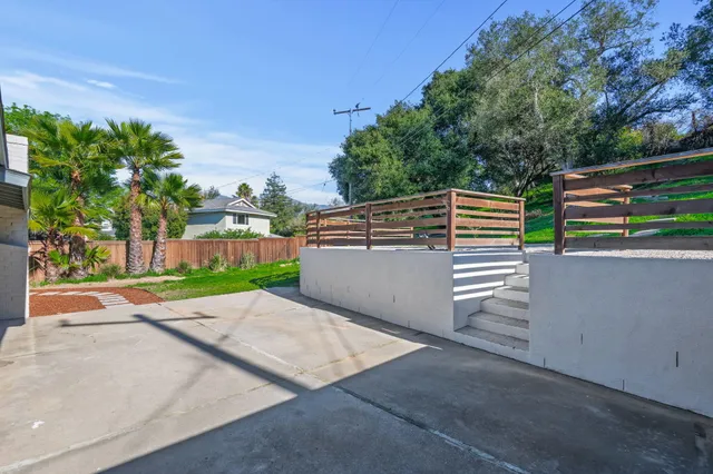 a view of a patio with table and chairs a barbeque with wooden fence