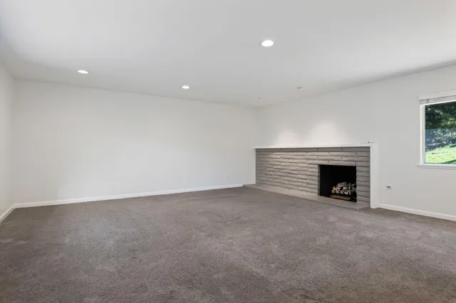 an empty room with a fireplace and window
