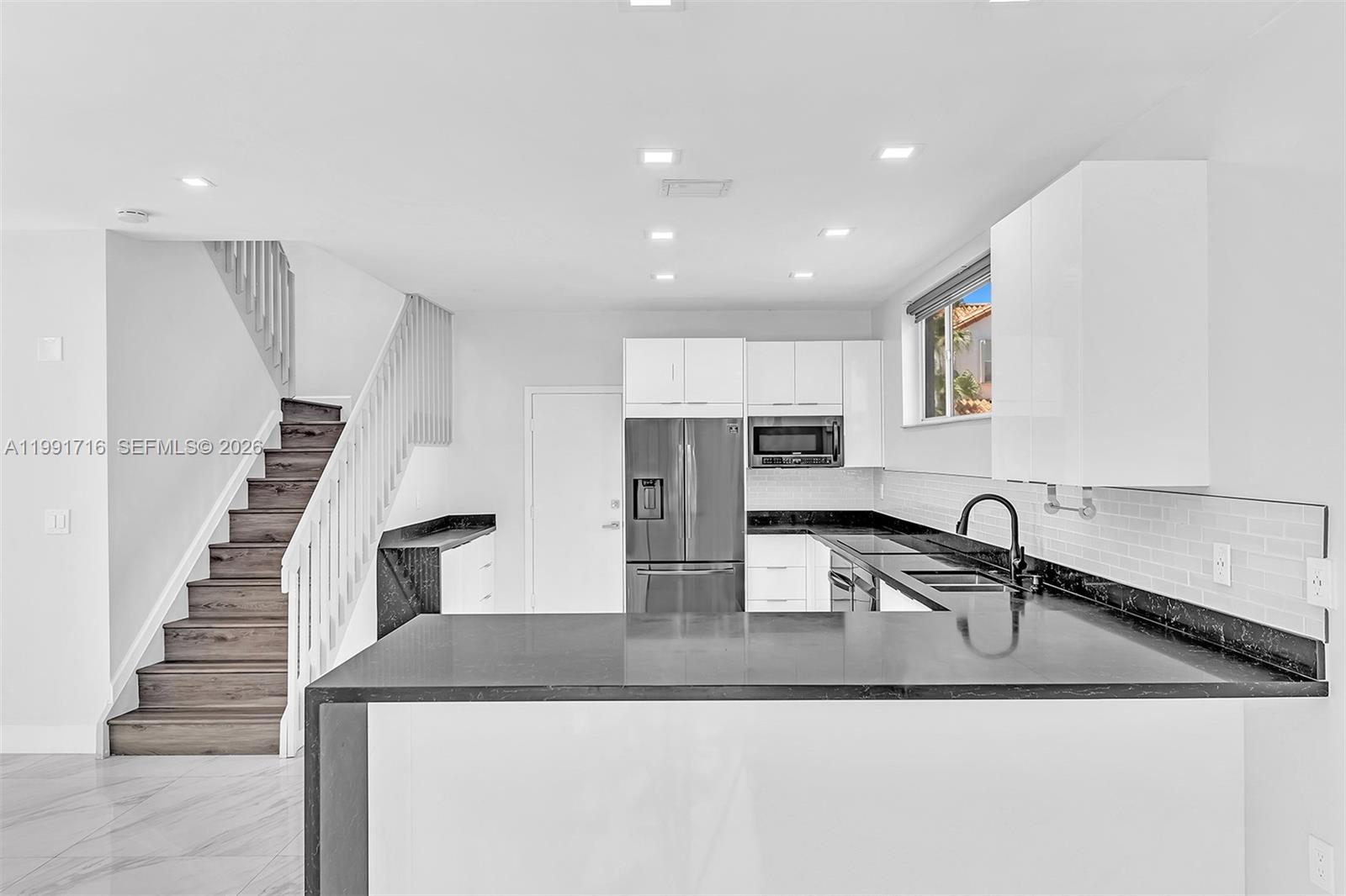 3085 North 36th Avenue Hollywood, FL 33021 - Photo 21 of 76 a kitchen with granite countertop a sink and a stove top oven with wooden floor