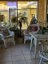 a living room with a table chairs and a floor to ceiling window