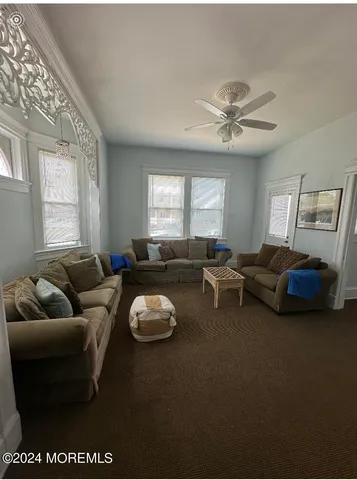 a living room with furniture ceiling fan and a window