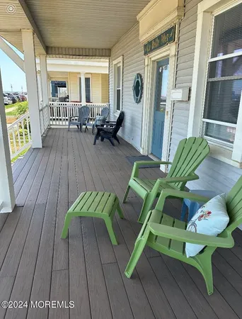 a view of a patio with couches table and chairs and wooden floor