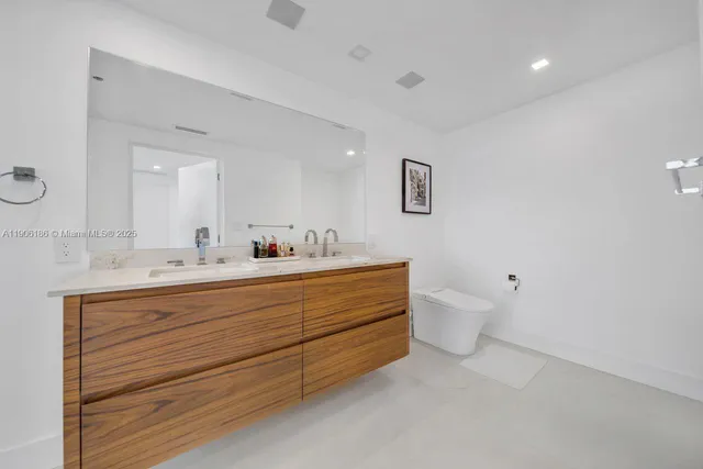 a bathroom with a double vanity sink mirror and toilet
