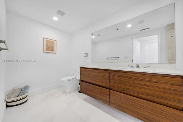 a bathroom with a toilet a sink and mirror