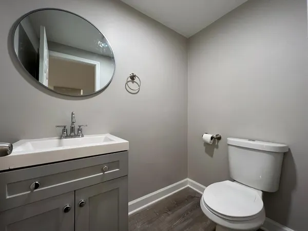 a bathroom with a toilet a sink and mirror