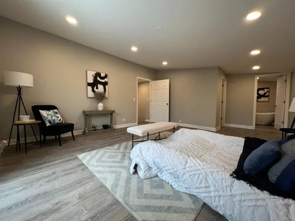 a spacious bedroom with a bed and a dresser