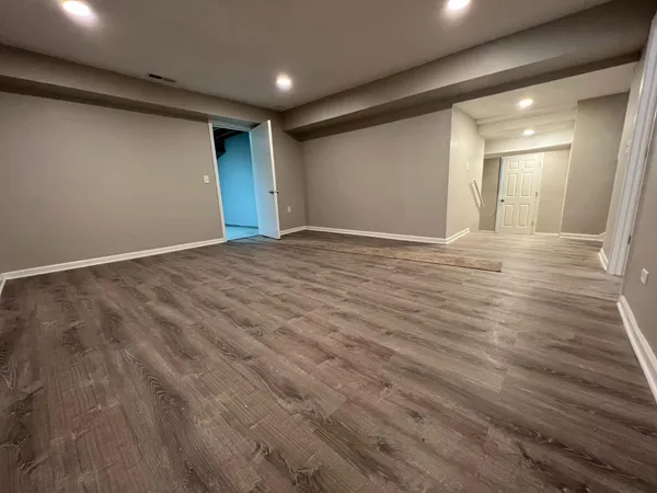 a view of an empty room with wooden floor