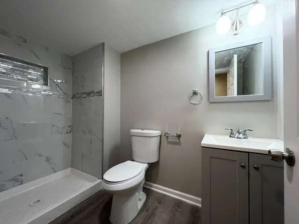 a bathroom with a sink a toilet and shower