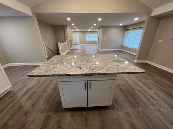 a view of a kitchen with kitchen island a sink dishwasher and wooden floor