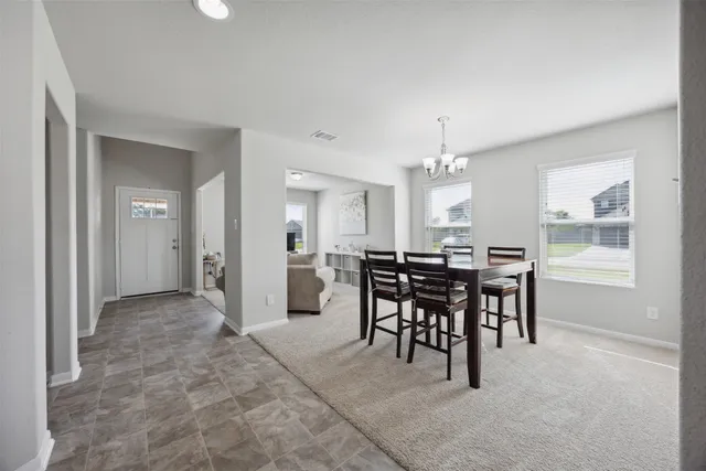 a view of a dining room with furniture and chandelier