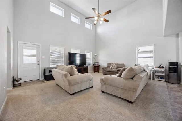 a living room with furniture a ceiling fan a fireplace and a window