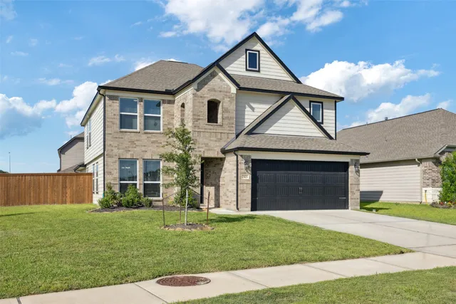 a front view of a house with a garden and yard