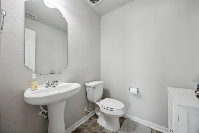 a bathroom with a sink a toilet and mirror