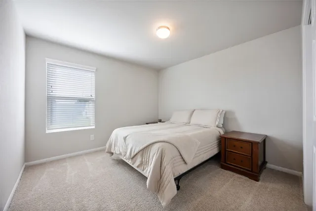 a bed sitting in a bedroom next to a window