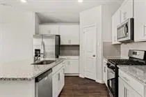 a kitchen with white cabinets and stainless steel appliances