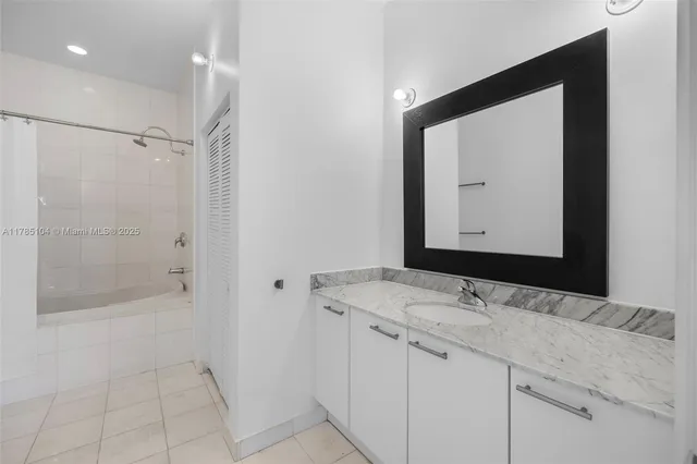 a bathroom with a double vanity sink mirror and shower