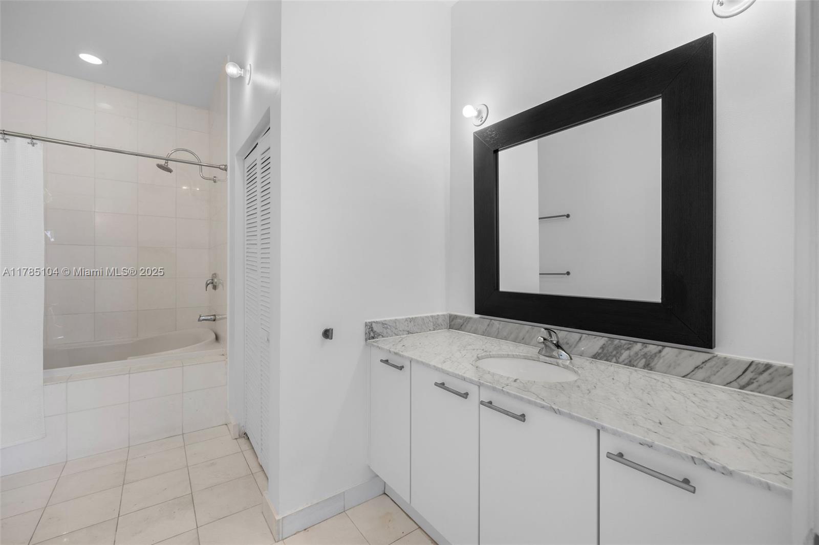 2001 Meridian Avenue, Unit 412 Miami Beach, FL 33139 - Photo 5 of 31 a bathroom with a double vanity sink mirror and shower