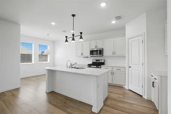 a kitchen with stainless steel appliances a sink stove and refrigerator