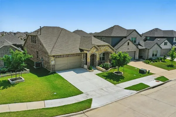 a front view of a house with a garden and yard