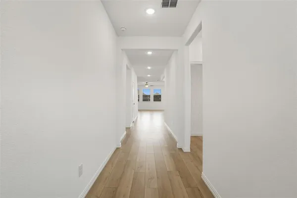 a view of a hallway with wooden floor