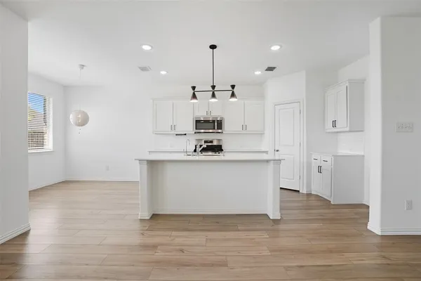 a view of kitchen with granite countertop stove top oven and cabinets