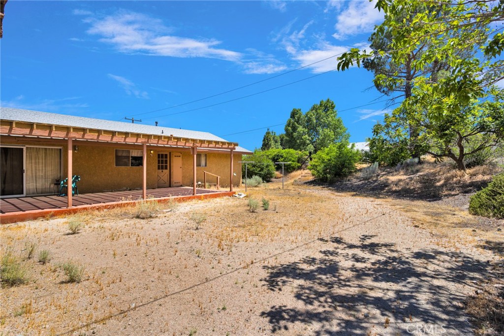5500 Oil Well Road Phelan, CA 92371 - Photo 40 of 65 a front view of a house with a dirt yard and a garage