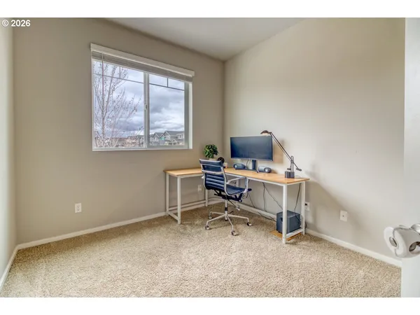 a view of a workspace with furniture and a window
