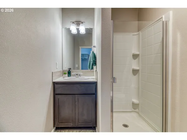 a bathroom with a sink a mirror a vanity and a shower