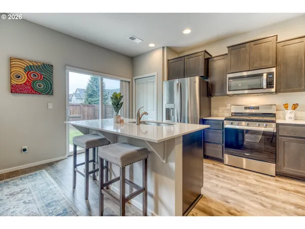 a kitchen with stainless steel appliances kitchen island granite countertop a sink and cabinets