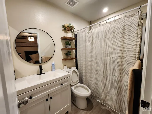 a bathroom with a sink mirror vanity and toilet