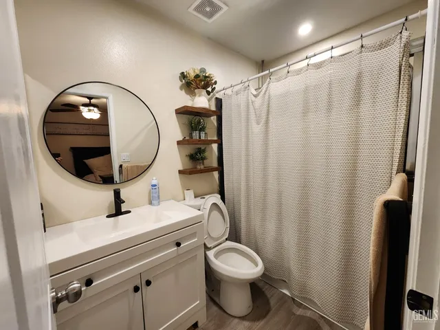 a bathroom with a sink mirror vanity and toilet